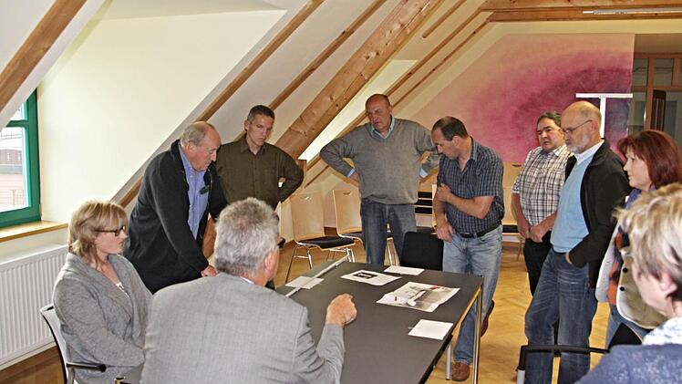 Bürgermeister Helmut Dietz (Rücken zum Bild) erörtert mit seinem Gemeinderat (von links) Sandra Schramm, Gerhard Roth, Robert Bohla, Jürgen Fromm, Gerald Karl, Dieter Reisenweber, 2. Bürgermeister Siegfried Kirchner und Birgit Finzel das Für und Wider der angebotenen Tische und Stühle. Foto: Helmut Will