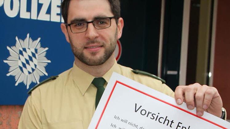 Aufruf zur Wachsamkeit: Daniel Seeburg, seit Mitte Januar stellvertretender Leiter der Dienststelle Bad Brückenau, präsentiert ein Plakat, das vor Betrugsmaschen warnt. Foto: Ulrike Müller