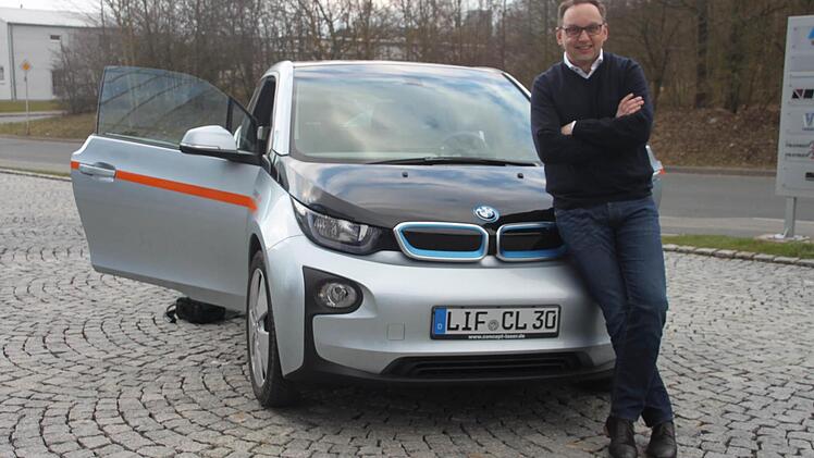 Frank Herzog mit seinem Dienstfahrzeug - dem BMW i3. Foto: Sarah Zubel