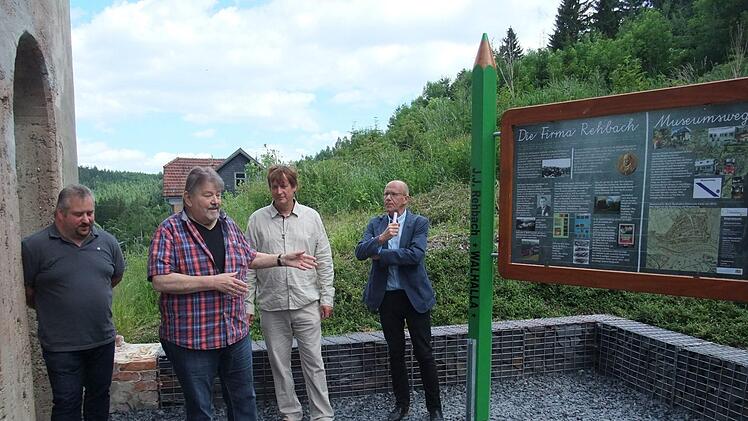 Gerd Daum (Zweiter von links) schildert in amüsanter Weise den langjährigen Werdegang zur Schaffung der Gedenkanlage mit der zuvor enthüllten Erinnerungstafel an die frühere Firma Rehbach. Michael Büttner (links) gehört zum tatkräftigen Nachbarschaftsteam, dessen Leistung von Zweitem Bürgermeister Ludwig Pötzinger (rechts) und Firmensohn Marco Pensel gewürdigt wurde.  Foto: Norbert Neugebauer