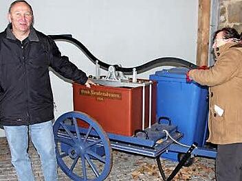 Für Gerätschaften, wie diese alte Pumpe, an der sich Brunhilde Giegold (rechts) und Werner Riegel versuchten, sucht die Reutersbrunner Feuerwehr eine Unterstellmöglichkeit. Foto: Ralf Kestel