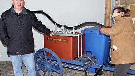 Für Gerätschaften, wie diese alte Pumpe, an der sich Brunhilde Giegold (rechts) und Werner Riegel versuchten, sucht die Reutersbrunner Feuerwehr eine Unterstellmöglichkeit. Foto: Ralf Kestel
