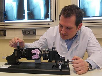 Stefan Sesselmann spannt ein künstliches Kniegelenk aus Vollkeramik in das "Phantom". Mit diesem Gerät kann die Belastbarkeit des Werkstoffs im Langzeitversuch getestet werden. Foto: privat