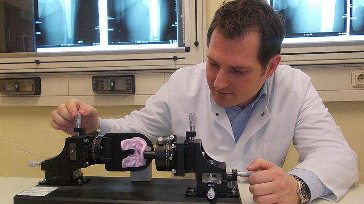 Stefan Sesselmann spannt ein künstliches Kniegelenk aus Vollkeramik in das "Phantom". Mit diesem Gerät kann die Belastbarkeit des Werkstoffs im Langzeitversuch getestet werden. Foto: privat