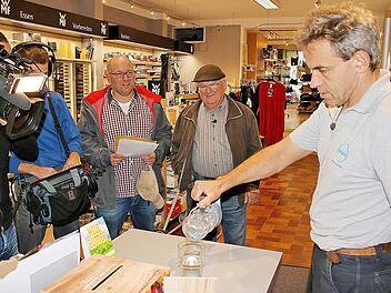 Paul Schmitt (zweiter von rechts) hat "Paul's Flaschenhalter" erfunden. Arno Reuscher (rechts) ist begeistert und will das Gerät in das Sortiment von von Eisen-Krais aufnehmen. Michael Kästner (dritter von rechts) war mit einem Kamerateam des Mitteldeutschen Rundfunks vor Ort und will den Flaschenhalter im Erfindermagazin des Senders vorstellen.  Foto: Dieter Britz