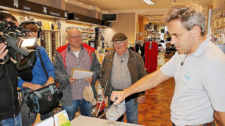 Paul Schmitt (zweiter von rechts) hat "Paul's Flaschenhalter" erfunden. Arno Reuscher (rechts) ist begeistert und will das Gerät in das Sortiment von von Eisen-Krais aufnehmen. Michael Kästner (dritter von rechts) war mit einem Kamerateam des Mitteldeutschen Rundfunks vor Ort und will den Flaschenhalter im Erfindermagazin des Senders vorstellen.  Foto: Dieter Britz