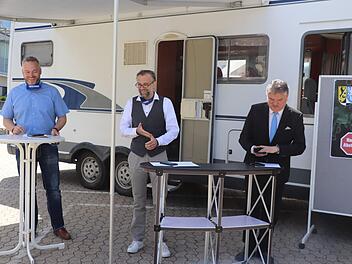 Yves Wächter und Oliver Hempfling von der Führungsgruppe Katastrophenschutz und Landrat Klaus Peter Söllner (von links), vor einem Wohnmobil, das als rollende Abstrichstelle eingesetzt wurde.