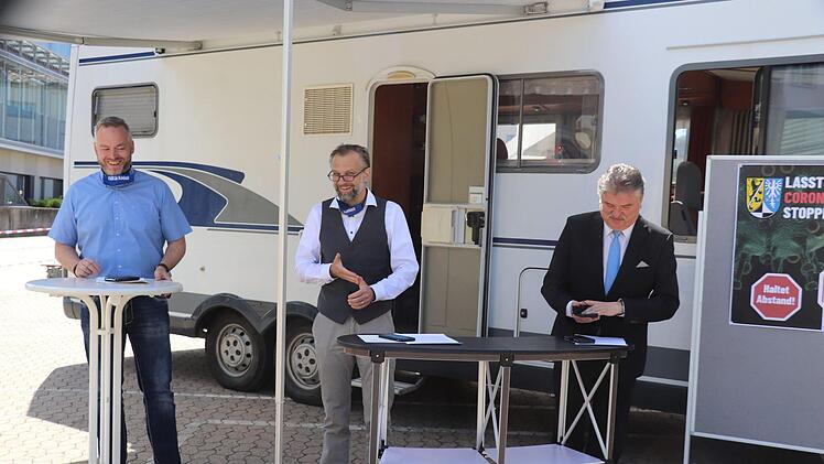 Yves Wächter und Oliver Hempfling von der Führungsgruppe Katastrophenschutz und Landrat Klaus Peter Söllner (von links), vor einem Wohnmobil, das als rollende Abstrichstelle eingesetzt wurde.