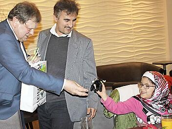 Der Unternehmer Carl-August Heinz beschenkt das Kind einer Flüchtlingsfamilie.  Fotos: Veronika Schadeck