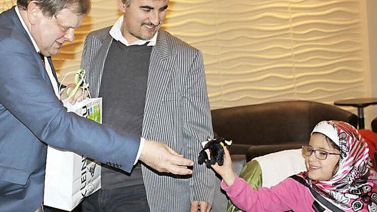 Der Unternehmer Carl-August Heinz beschenkt das Kind einer Flüchtlingsfamilie.  Fotos: Veronika Schadeck