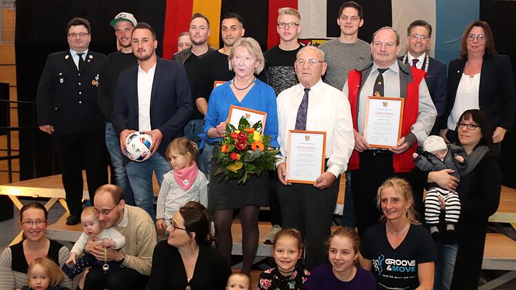 Die Geehrten posieren gemeinsam mit den Eltern der "Neubürger" und Funktionären von BRK und Feuerwehr. Fotos: Johanna Blum