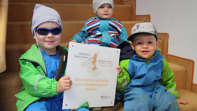 Julian Naumann, Oskar Köber und Flynn Weeber halten das KitaPlus-Schild, das künftig den Eingang der Herbert-Kneitz-Kindertagesstätte Wirsberg zieren soll, hoch.