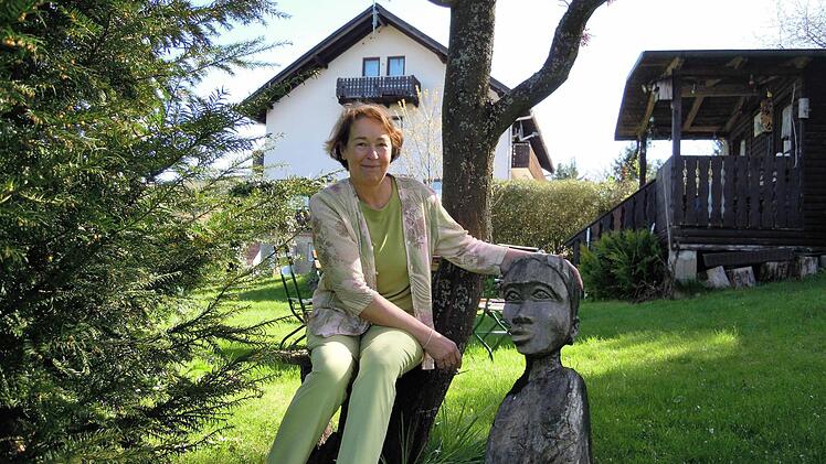 Hannelore Baier vor dem Café Sonnenkanzel. Den geschnitzten Kopf hat sie auf einer ihrer Afrika-Reisen entdeckt und mit nach Deutschland gebracht. Foto: Julia Raab