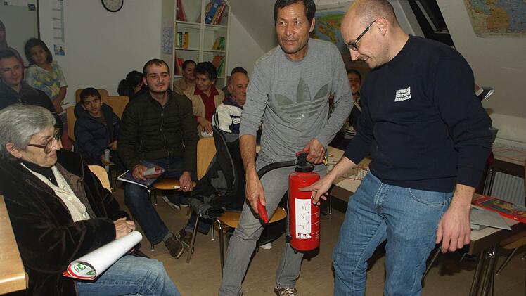 In der Asylunterkunft in der Bahnhofstraße erklärte Fabian Wahler von der Feuerwehr den fachgerechten Umgang mit einem Feuerlöscher.  Fotos: Stefan Geiger