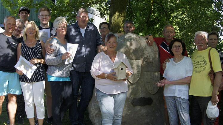 Nord-und Süd-Volkerser an dem Stein, den Volkers-Süd 1989 als Gastgeschenk mitgebracht hatte. Das Foto entstand 2017 beim Brunnenfest mit Luftkegeln im letzten Jahr in Volkers-Nord. Foto: Michaela Fischer