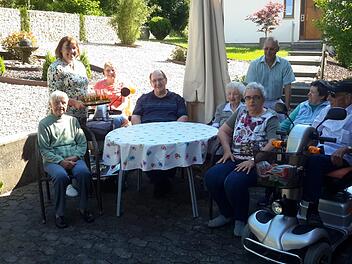 Die Wohngruppe der Senioren harmoniert und sitzt gern draußen zum gemütlichen Plausch zusammen. Die Pensionsinhaber Gundula Langeworth (links stehend) und ihr Mann Hans-Joachim (hinten rechts) sind in ständigem Kontakt mit ihren Dauergästen. Foto: Rolf Pralle