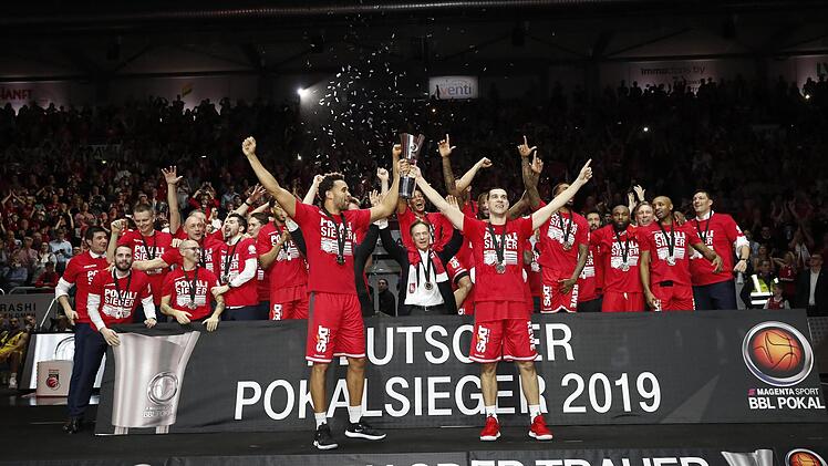Nikos Zisis und Elias Harris stemmen den Pokal in die Höhe, beim Brose-Team kennt die Begeisterung keine Grenzen.  Fotos: Daniel Löb