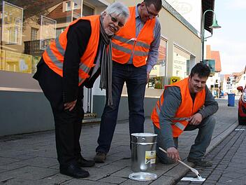 Bürgermeister Wolfgang Back (von links) und Bauhof-Leiter Bernhard Schaupp schauen Mitarbeiter Peter Böb beim Nachmalen der Markierungen auf Bad Bocklets Straßen über die Schulter. Foto: Ralf Ruppert