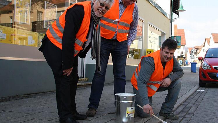 Bürgermeister Wolfgang Back (von links) und Bauhof-Leiter Bernhard Schaupp schauen Mitarbeiter Peter Böb beim Nachmalen der Markierungen auf Bad Bocklets Straßen über die Schulter. Foto: Ralf Ruppert