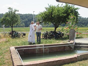 Diakon Klaus Müller (l.) segnete das Werk und übergab das neue Tretbecken in Gottes Hände.