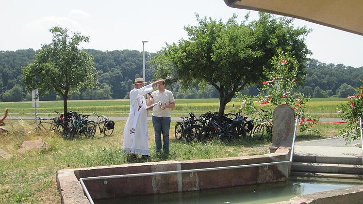 Diakon Klaus Müller (l.) segnete das Werk und übergab das neue Tretbecken in Gottes Hände.