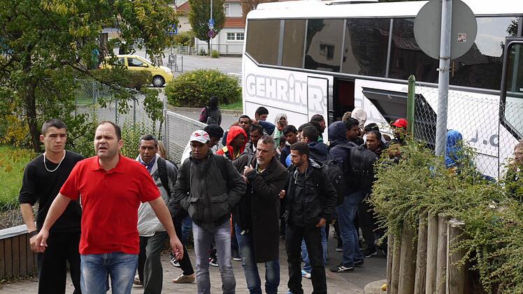 Haldun Yildirim (Mitte in rot) weist den 44 neuen Ankömmlingen den Weg in ihre vorübergehende Unterkunft.  Foto: Pauline Lindner