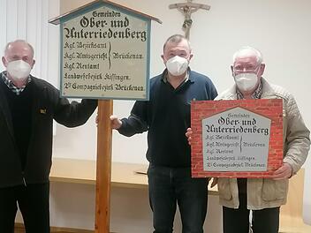 Werner Vieres (links) und Arnim Waldau (rechts) überreichten Bürgermeister Roland Römmelt die aufwendig restaurierte historische Gemeindetafel.