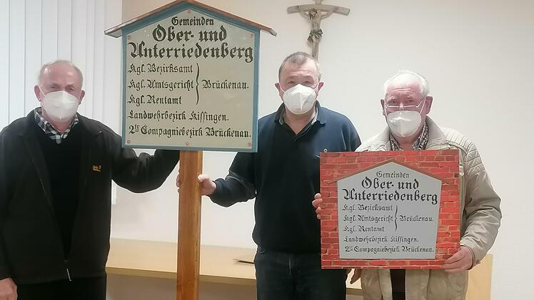 Werner Vieres (links) und Arnim Waldau (rechts) überreichten Bürgermeister Roland Römmelt die aufwendig restaurierte historische Gemeindetafel.