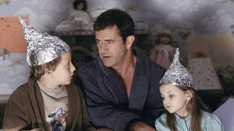 Ex-Priester Graham Hess (Mel Gibson, Mitte) versucht, seinen Kindern Morgan (Rory Culkin, links) und Bo (Abigail Breslin) die Angst vor dem Unbekannten im Maisfeld zu nehmen.