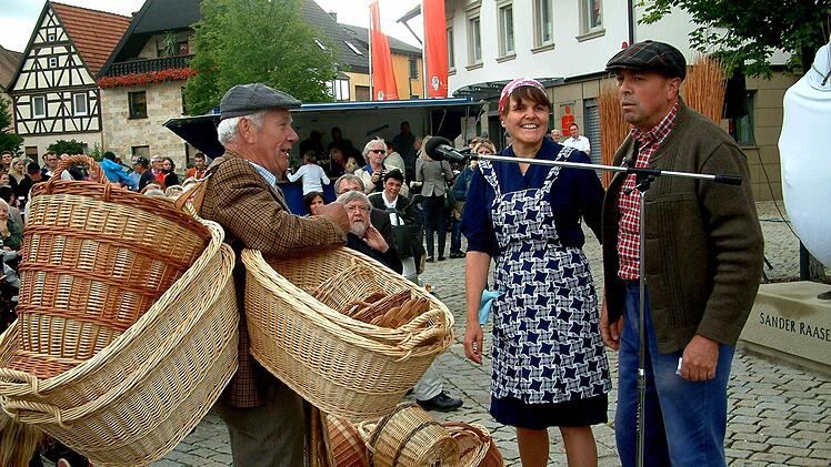 In einer Spielszene führten Rudi Rippstein sowie Karin und Ralf Wagner auf etwas humorvolle Art vor, wie die Sander Raaser in früheren Jahren ihre Korbwaren bei Haustürgeschäften an den Mann bzw. die Frau brachten. Fotos Alfons Beuerlein