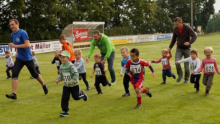 Die Jüngsten nehmen den Bambini-Lauf mit der Unterstützung ihrer Väter in Angriff.