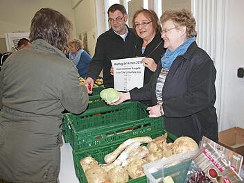 Zum Welttag der Armen wurden in der Lichtenfelser Tafel plus die Lebensmittel kostenlos ausgegeben. Hier bedienen die ehrenamtliche Helferin Brigitte Körner, Sozialpädagogin Beate Ehl (mit Plakat) und der Geschäftsführer des Kreiscaritasverbandes, Thomas Geldner, eine Kundin. Foto: Alfred Thieret