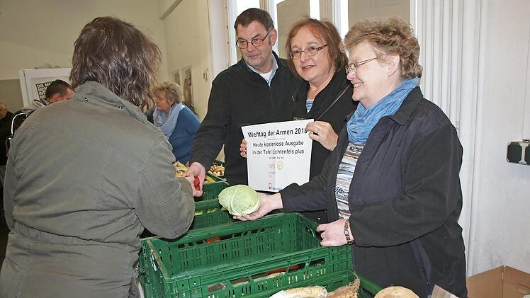 Zum Welttag der Armen wurden in der Lichtenfelser Tafel plus die Lebensmittel kostenlos ausgegeben. Hier bedienen die ehrenamtliche Helferin Brigitte Körner, Sozialpädagogin Beate Ehl (mit Plakat) und der Geschäftsführer des Kreiscaritasverbandes, Thomas Geldner, eine Kundin. Foto: Alfred Thieret