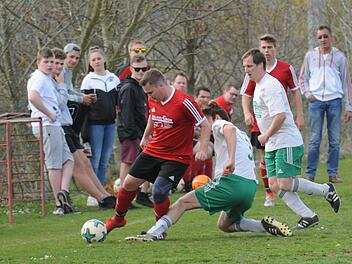 Oehrbergs Spielertrainer Alexander Schleicher (rotes Trikot) setzt sich in einem umkämpften Spiel gegen Andreas Henning (grätschend) von der SG Gräfendorf II durch. Foto: ssp
