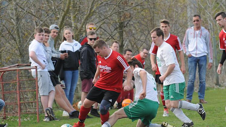 Oehrbergs Spielertrainer Alexander Schleicher (rotes Trikot) setzt sich in einem umkämpften Spiel gegen Andreas Henning (grätschend) von der SG Gräfendorf II durch. Foto: ssp