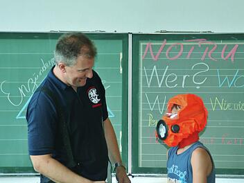 Ganz schön eng: Harry probiert die Brandfluchthaube aus. Foto: Werner Vogel