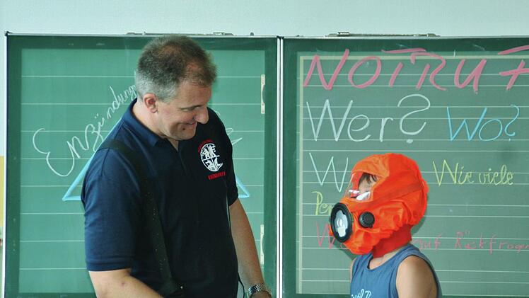 Ganz schön eng: Harry probiert die Brandfluchthaube aus. Foto: Werner Vogel