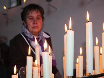 Eine Pilgerin entzündet eine Kerze. Foto: Ulrike Müller