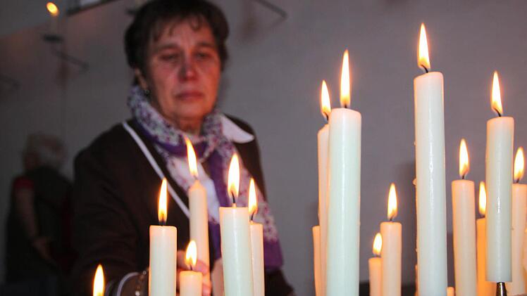 Eine Pilgerin entzündet eine Kerze. Foto: Ulrike Müller