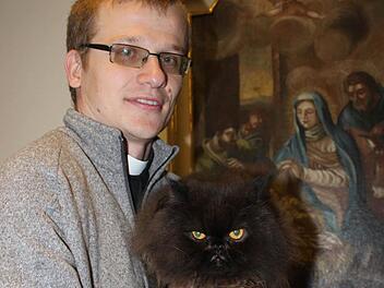 Pfarrvikar Grzegorz Grinn mit seinem Perserkater "Happy" im PfarrhausFoto: Markus Häggberg