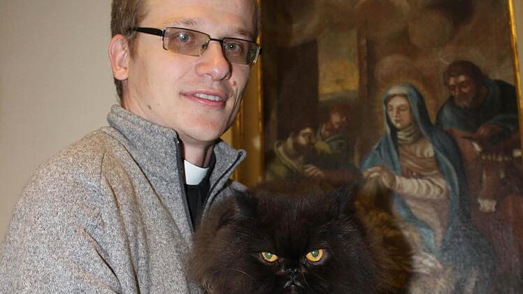 Pfarrvikar Grzegorz Grinn mit seinem Perserkater "Happy" im PfarrhausFoto: Markus Häggberg