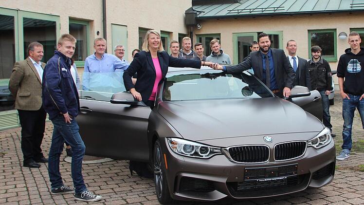 BMW-Mitarbeiterin Manuela Rimbeck übergibt die Autoschlüssel an KFZ-Lehrer Robert Pfaller.  Foto: Jana Röckelein