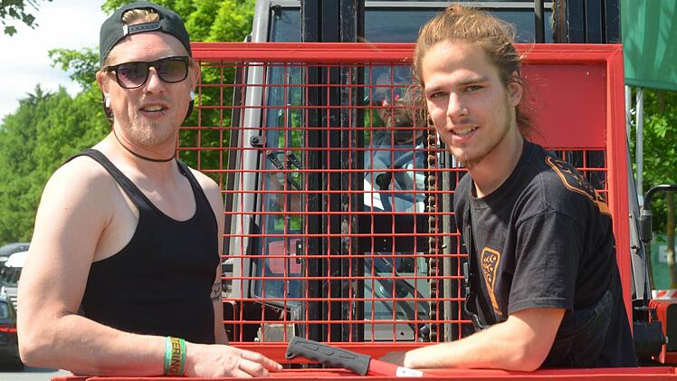 Kashi und Samuel schneiden Äste, damit die Schilder für Fluchtwege besser erkannt werden können. Foto: Nikolas Pelke
