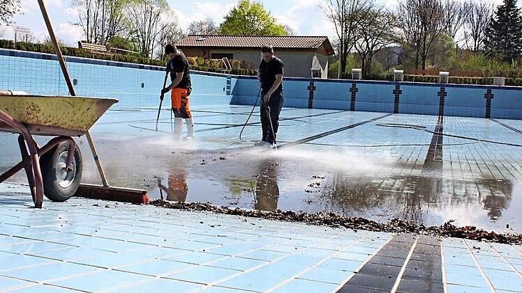 Michael Hanke und sein Auszubildender Oliver Fischer (v.l.) beim Reinigen des 50-Meter-Sportbeckens im Redwitzer Freibad. Die größte Fläche haben sie bereits geschafft. Fotos: Popp