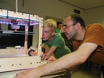 Gleichermaßen fasziniert schauen Lehrer Wolfgang Lormes und Patrick Bär der Entstehung des Roboters zu. 39 Minuten braucht der Drucker für die kleine Figur. Foto: Sonja Adam