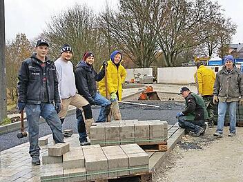 Regen bremst sie nicht: Pascal und Michael Gülta, Martin Lapré, Uwe Endres, Peter Heppt, Daniel Zapf und Edgar Burger (von links) pflasterten das Umfeld des Kirchaicher Friedhofs. Foto: Sabine Weinbeer