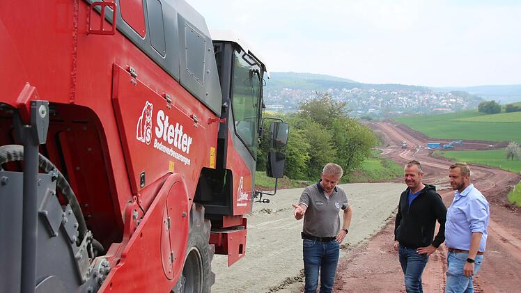 Oberbauleiter Steffen Kiesel vom Landratsamt (links), Polier Alexander Wirsing und Bauleiter Thomas Huber (beide Glöcke-Bau) beobachten das Einfräsen des Bindemittelgemisches. Das ist notwendig um in Teilbereichen der Kreisstraße 1 die Tragfähigkeit zu verbessern. Foto: Thomas Malz