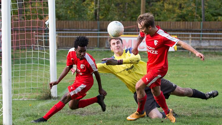 Obersdorfs Keeper Matthias Wei&szlig; kann einen Freisto&szlig; nicht festhalten, aber die Kronacher Daniel Kebede (rotes Trikot, links) und Andre Zapf (rechts) schaffen es nicht, den Ball &uuml;ber die Torlinie zu bef&ouml;rdern.  Foto: Wei&szlig;