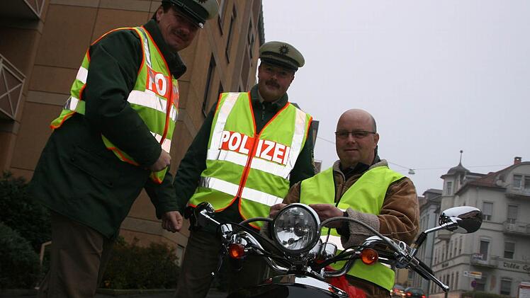 Daniel Mohr (rechts) fühlt sich jetzt sicherer auf seinem Vespa-Roller. Mit der Warnweste, die ihm Matthias Kleren (links) und Martin Kaiser überreichten, wird er im morgendlichen Berufsverkehr besser erkannt. Fotos: Paul Ziegler