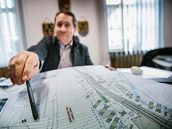 Die dicke Linie rechts auf dem Plan zeigt die kommende Ortsumgehung Zeyern. Marktrodachs Bürgermeister Norbert Gräbner weist auf einen Bereich nahe der Gemarkung. Dort könnte ein neues Misch-Baugebiet entstehen.  Foto: Hednrik Steffens